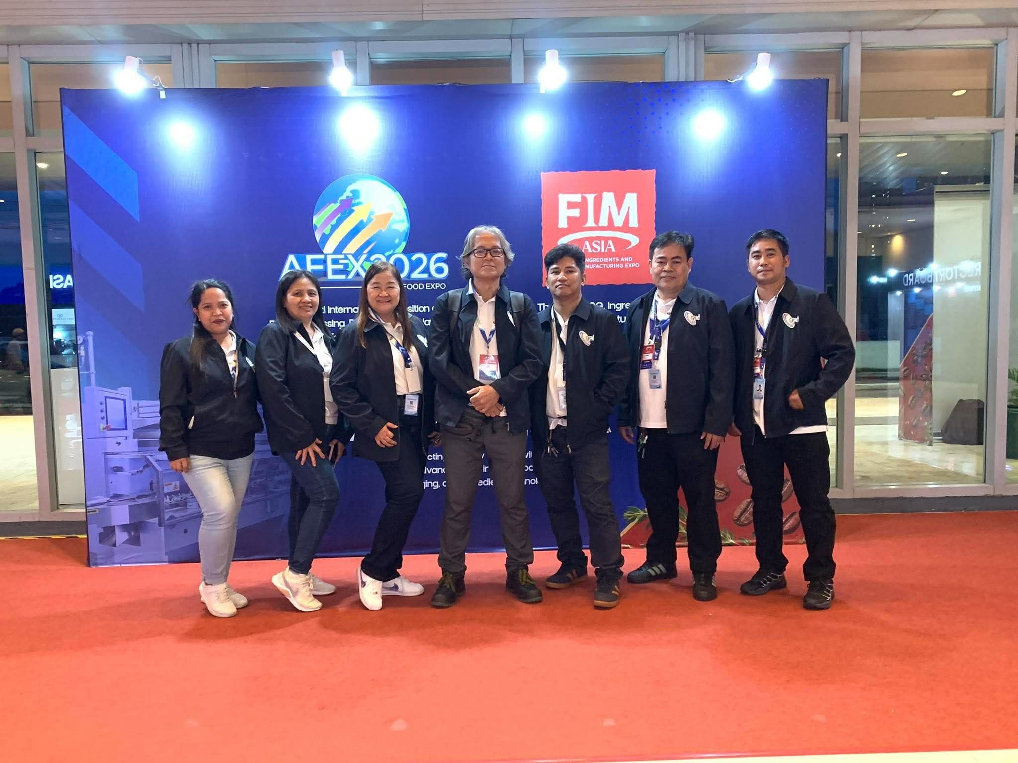 Seven members of the Gerconcepts team in black jackets standing in front of the AFEX 2026 and FIM Asia backdrop